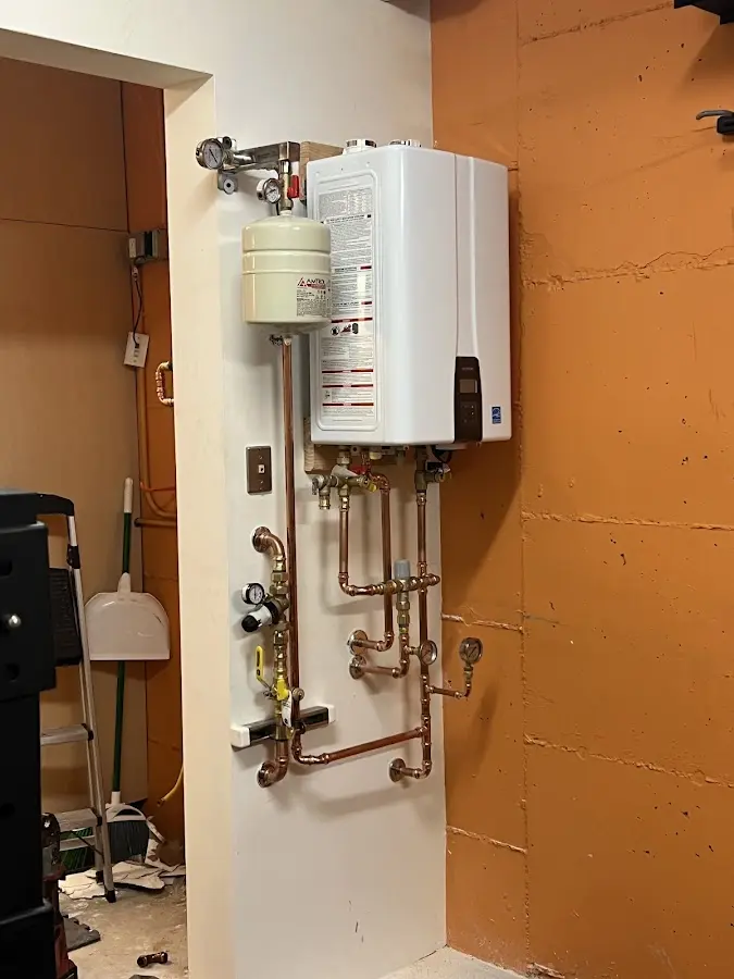 Plumbing technician inspecting water heater connections in Eastern Goleta Valley